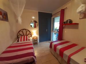 ein Schlafzimmer mit zwei Betten und einem Fenster in der Unterkunft Les Gites Capra - Papaye in Bouillante