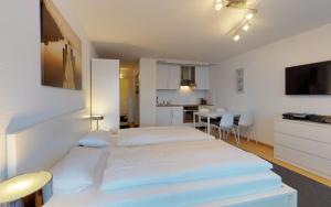 ein Hotelzimmer mit 2 Betten und einer Küche in der Unterkunft Lac 16 in St. Moritz