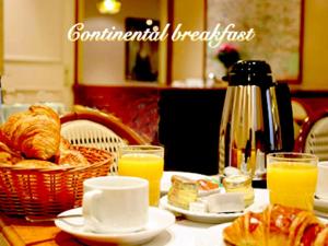 a table with a breakfast of bread and orange juice at St. George's Lodge in Kingston upon Thames