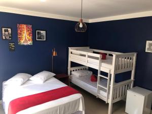 1 dormitorio con 2 literas y paredes azules en Mundo Livre Guest House, en Penha