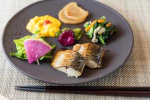 Super Hotel Echizen Takefu في Echizen: صحن أسود مع طعام على طاولة