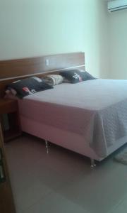 a bedroom with a large bed with a wooden headboard at Conforto e Comodidade Porto Seguro BA in Porto Seguro
