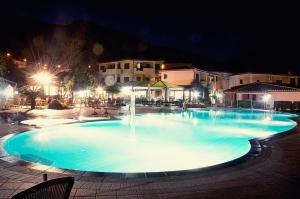 a large swimming pool at night with a fountain at Club Parco Blu in Cala Gonone