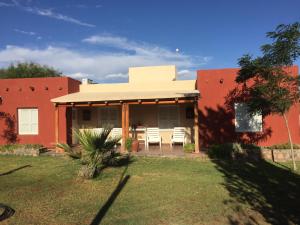 una casa rossa con tavolo e sedie nel cortile di Cabaña Chañares de Banda Florida - Ama a Villa Unión