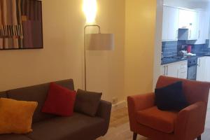 sala de estar con sofá y silla en Garland Modern House With Parking & Garden Croydon en Croydon