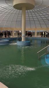 ein großes Gebäude mit einem Pool mit grünem Wasser in der Unterkunft CABAÑAS PARQUE TERMAL DOLORES in Dolores