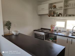a kitchen with a black counter top and a stove at Departamento Papudo in Papudo