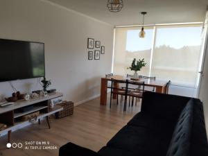 a living room with a couch and a dining room at Departamento Papudo in Papudo