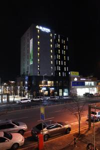 eine Stadtstraße mit Autos, die vor einem Gebäude geparkt sind in der Unterkunft S& Hotel in Daejeon
