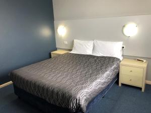 a hotel room with a bed and two night stands at Flinders Motel in Wollongong