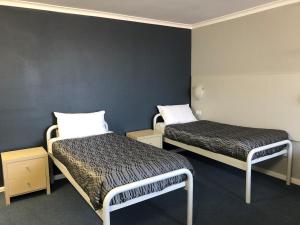 Habitación con 2 camas en una habitación en Flinders Motel, en Wollongong