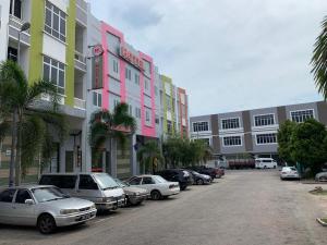 a parking lot with cars parked in front of a building at MK Paradise hotel in Tangkak