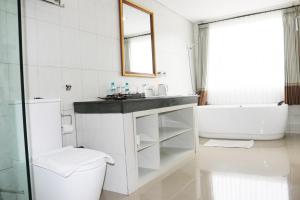 a bathroom with a toilet and a sink and a tub at Puri Saron Hotel Baruna Beach Lovina in Lovina