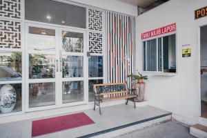 a building with a bench in front of a store at RedDoorz Apartment @ Batam Centre 3 in Batam Center
