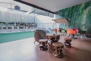 a room with a table and chairs and a painting at RedDoorz Apartment @ Batam Centre 3 in Batam Center