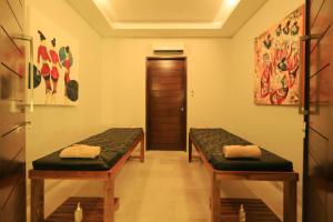 a room with two benches in front of a door at Living Asia Resort and Spa in Senggigi