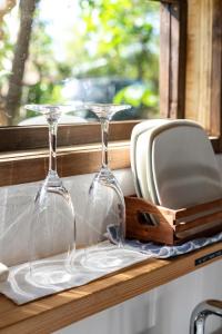 two wine glasses sitting on a window sill at Tree-house Hotel Morinosubako in Nakijin