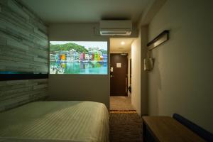 Super Hotel Echizen Takefu في Echizen: غرفة بسرير ودهان على الحائط