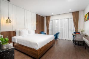 una camera d'albergo con un grande letto e una scrivania di Sharon Hotel and Apartment a Da Nang