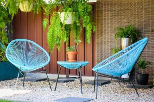 3 chaises bleues et une table sur la terrasse dans l'établissement Dell-Lee Cottage, à Broke