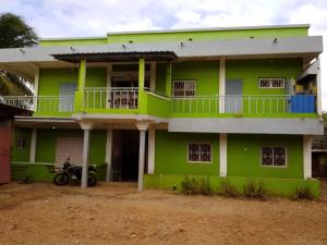a green house with a motorcycle parked in front of it at Appartement F2 50m2 centre ville sécurisé in Antsiranana