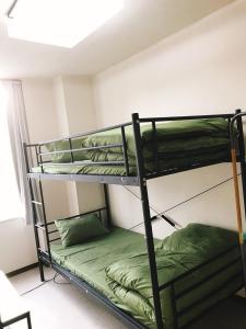 two bunk beds in a room with a window at Joinus Ise Apartment in Ise