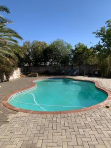una piccola piscina con patio in mattoni di One More Nap Self Catering a Bloemfontein