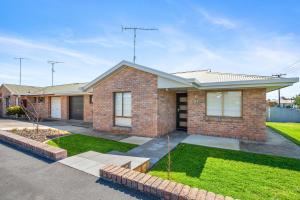 a brick house with a lawn in front of it at City Four Apartment in Mount Gambier