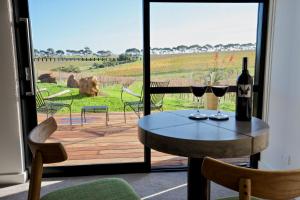 einen Tisch mit zwei Gläsern Wein auf einer Terrasse in der Unterkunft Hotel California Road at Inkwell Wines in McLaren Vale