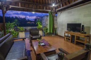 a living room with a television and a table at Bali Spirit Hotel and Spa, Ubud in Ubud