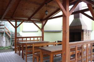 um pavilhão de madeira com mesas e uma lareira em Penzión Koras em Vrútky