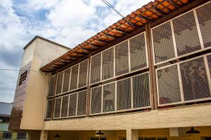 a building with a bunch of shuttered windows on it at Flor de Lis Hostel in Viçosa