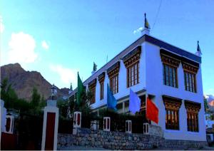 un edificio blanco con banderas delante en Hotel Mahay Palace en Leh