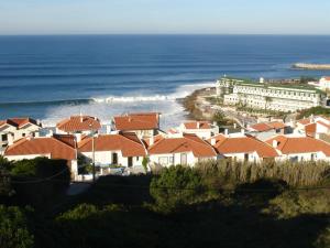 a group of houses with the ocean in the background at Design Apartments in Ericeira