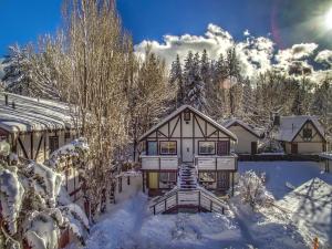 a home in the snow with snow covered trees at Big Bear Spa Suites in Big Bear Lake