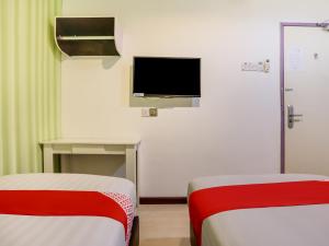 een kamer met 2 bedden en een tv aan de muur bij OYO 89583 Grove Hotel in Kajang