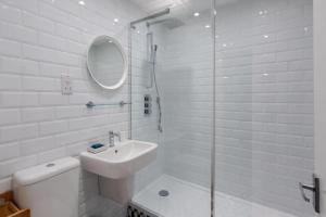 a white bathroom with a sink and a shower at GuestReady - 1BR Flat Ideally Located In Zone 2 Fits 3 in London