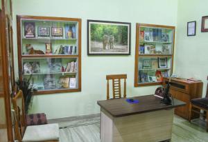 um quarto com uma secretária e prateleiras com livros em Ranthambore Tiger Home em Sawai Madhopur