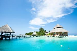 a beach with a pier and huts on the water at Adaaran Club Rannalhi - All Inclusive - 45 Minutes away from Male by Speedboat in South Male Atoll