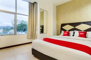 En eller flere senge i et værelse på OYO 89583 Grove Hotel