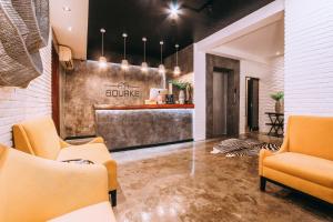 a lobby with orange chairs and a bar at The Bourke Hotel in Davao City