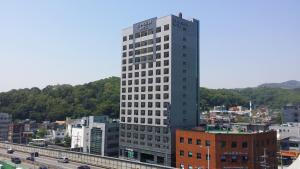 a tall white building in the middle of a city at CS Premier Hotel in Anyang