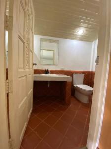 a bathroom with a toilet and a sink and a mirror at Haadson Resort & Koh Raham in Haad Son