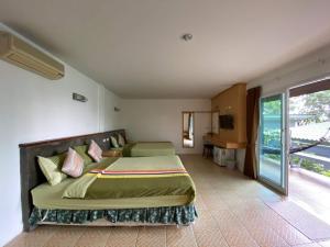 a bedroom with a bed and a large window at Haadson Resort & Koh Raham in Haad Son