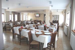 a dining room with tables and chairs in a restaurant at Pension Laura Cheile Turzii in Petreştii de Jos