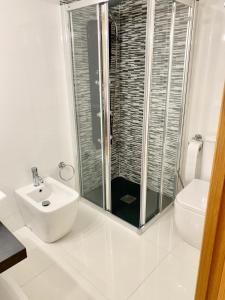 a white bathroom with a shower and a sink at Apto Alma Parking y Piscina GRATIS in Zaragoza +10 photos