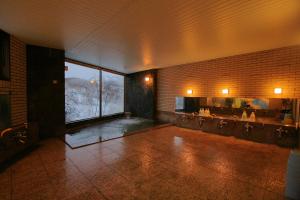 ein Badezimmer mit Badewanne und großem Fenster in der Unterkunft Hotel Araragi in Yamanouchi