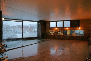 Großes Zimmer mit einem Pool in einem Gebäude in der Unterkunft Hotel Araragi in Yamanouchi