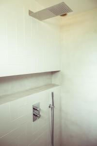 um chuveiro na casa de banho com uma parede de azulejos brancos em Le Canaillou par Dodo-a-Cassis em Cassis