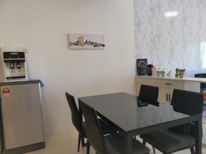 a kitchen with a table and chairs and a refrigerator at Cozy 3 Bedrooms Apartment Langkawi in Kuah